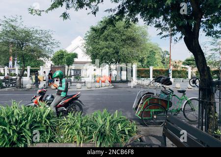 Yogyakarta, Indonesien - circa 2023: Schnappen Sie sich ein Motorrad-Taxi-Fahrer, der sein Handy auf Kunden abfragt. Stockfoto