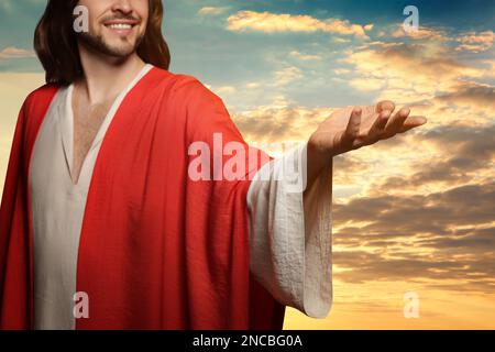 Jesus Christus streckte seine Hände aus und betete bei Sonnenuntergang Stockfoto