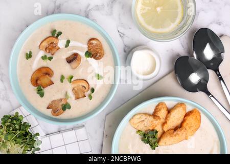 Köstliche Cremesuppe mit Pilzen, serviert auf einem weißen Marmortisch, flach liegend Stockfoto