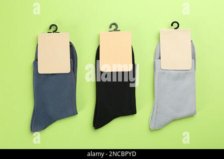 Weiche Baumwollsocken auf hellgrünem Hintergrund, flach liegend Stockfoto