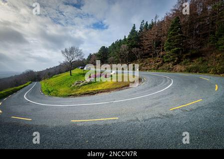 Haarnadelkrümmung auf der Bergstraße an einem hellbewölkten Tag in Irland. Stockfoto