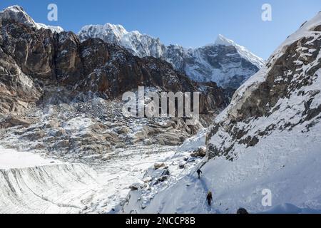 Extremes Trekking-Konzept. Gruppe von Reisenden, die auf dem Bergpfad im Himalaya, Nepal, spazieren. Alpenabenteuer - Bergsteiger, die einen Schnee überqueren Stockfoto