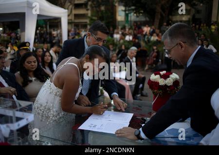 Caracas, Venezuela. 14. Februar 2023. Paare und Gäste nehmen an einer gemeinsamen Hochzeitszeremonie Teil, die von der Gemeinde Chacao im Rahmen der Valentinstagsfeiern auf der Plaza Francia organisiert wird. Hunderte Venezuelaner feierten den Valentinstag mit einer gemeinsamen Hochzeit auf der Plaza Altamira im Osten von Caracas, wo zehn Paare vor etwa 300 Betreuern heirateten. Kredit: Pedro Rances Mattey/dpa/Alamy Live News Stockfoto