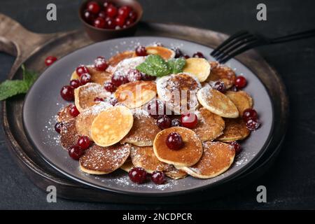 Müsli-Pfannkuchen mit Preiselbeeren auf schwarzem Tisch Stockfoto