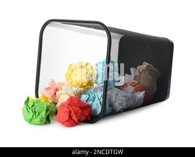 Korb mit verstreuten, zerknitterten Papierkugeln auf weißem Hintergrund Stockfoto