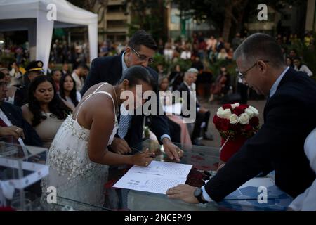 Caracas, Venezuela. 14. Februar 2023. Paare und Gäste nehmen an einer gemeinsamen Hochzeitszeremonie Teil, die von der Gemeinde Chacao im Rahmen der Valentinstagsfeiern auf der Plaza Francia organisiert wird. Hunderte Venezuelaner feierten den Valentinstag mit einer gemeinsamen Hochzeit auf der Plaza Altamira im Osten von Caracas, wo 24 Paare vor etwa 300 Betreuern heirateten. Kredit: Pedro Rances Mattey/dpa/Alamy Live News Stockfoto