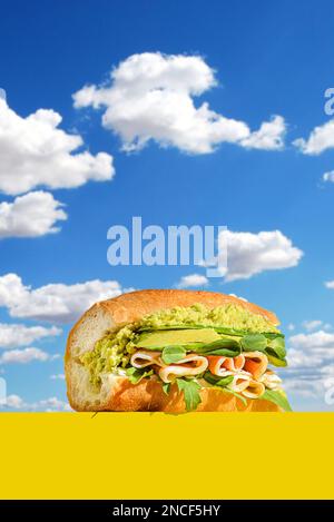 Baguette mit Avocado und parma. Gegen den Himmel in einem gelben Lieferkarton Stockfoto