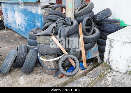 Ein großer Haufen Gebrauchtwagen-Reifen liegt am Straßenrand. Umweltverschmutzung Stockfoto