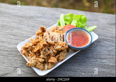 Gebratener Schweinedarm mit Knoblauch und Sauce auf dem Teller - Schweineabfälle Thai-Speisen oder Snacks Stockfoto