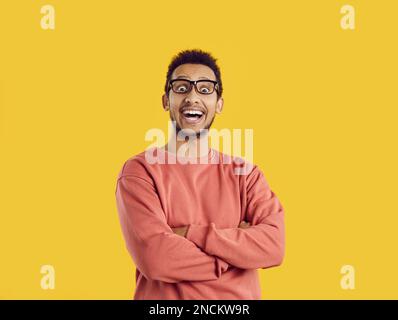 Porträt eines glücklichen, aufgeregten, jungen schwarzen Mannes mit Brille, der in die Kamera schaut und lacht Stockfoto