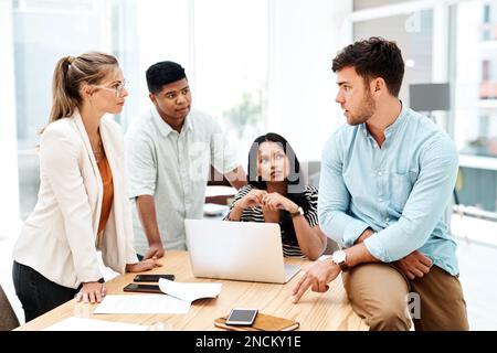 Neue und kreative Ideen als Team entwickeln. Eine Gruppe von Geschäftsleuten, die sich in einem Büro unterhalten. Stockfoto