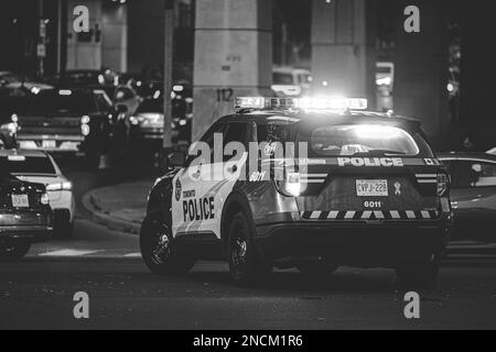 Ein Schwarz-Weiß-Foto vom Hinterteil einer Toronto Polizei mit aktivierter Notbeleuchtung Stockfoto