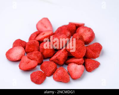 Gefriergetrocknete Erdbeere ist eine verarbeitete Frucht, die den Nährwert von Lebensmitteln behält. Ein Haufen gefriergetrockneter Erdbeeren, isoliert auf weißem Backgr Stockfoto