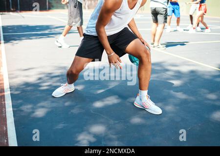Er hat Talent. Nahaufnahme eines sportlichen Mannes, der Basketball auf einem Sportplatz spielt. Stockfoto