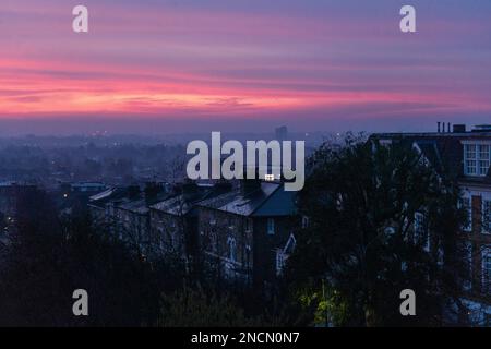 London, Großbritannien. 15. Februar 2023 Ein farbenfroher Sonnenaufgang mit rosa Himmel in Wimbledon, Südwesten Londons, an einem kalten, frostigen Morgen. Die Aussicht ist für hellen Sonnenschein später mit Temperaturen von bis zu 14degrees grad celsius. Credit: amer Ghazzal/Alamy Live News Stockfoto