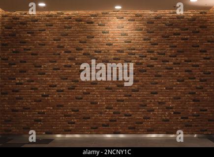 Backsteinwand in roter Farbe, Hintergrundbeleuchtung mit breiter Panoramatextur von oben Stockfoto