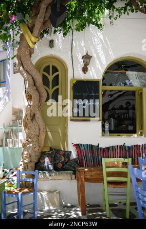 IOS, Griechenland - 2. Juni 2021 : Blick auf ein Bar-Restaurant mit malerischer Terrasse, farbenfrohen Stühlen und Kissen in den iOS kykladen Griechenlands Stockfoto