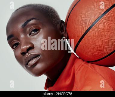 Ich Spiele keine Spiele, ich Gewinne sie. Studioaufnahme einer attraktiven jungen Frau, die Basketball vor grauem Hintergrund spielt. Stockfoto