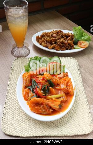 Serviert werden gebratene Garnelen in süßer und saurer Sauce mit einem Glas Orangensaft Stockfoto