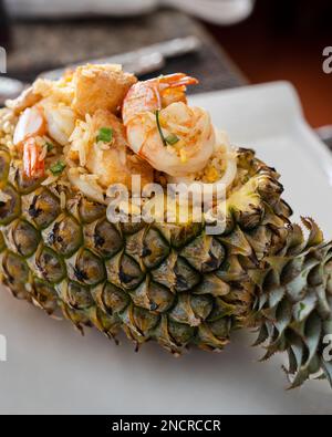 Garnelen und Ananas gebratener Reis serviert in einer ausgehöhlten Ananas in Mama Tri's Kitchen in der Nähe von Kata Noi Beach in Phuket. Stockfoto