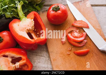 Tomatenscheiben liegen auf einem Holztisch Stockfoto