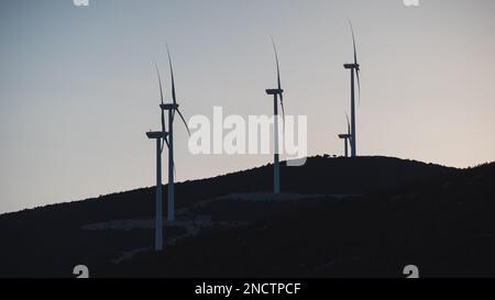 Die Windturbinen auf dem Gipfel eines Berges bei einem malerischen Sonnenuntergang Stockfoto