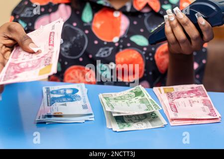 pos-Dame mit neuen Naira-Noten Stockfoto