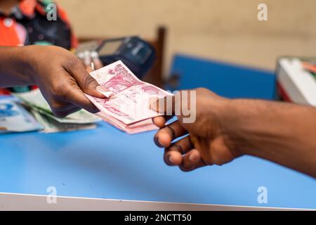 pos-Dame gibt dem Kunden neue Naira-Notizen Stockfoto