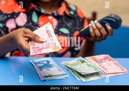 pos-Dame mit neuen Naira-Noten Stockfoto