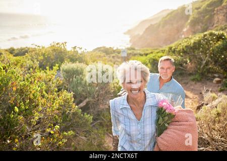 Wandern, Mockup und ein Seniorenpaar auf einem Valentinstag Picknick zusammen in den Bergen für Romantik. Die Natur, die Liebe und eine reife Frau, die sie führt Stockfoto