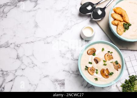 Köstliche Cremesuppe mit Pilzen, serviert auf einem weißen Marmortisch, flach liegend. Platz für Text Stockfoto