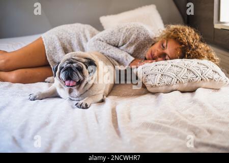 Leute, die schlafen und relaxte Freizeitaktivitäten im Wohnmobil haben, mit ihrem besten Freund Hund auf dem Bett. Konzept von Liebestier und Freunden Stockfoto
