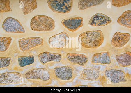 Stein Wand als Hintergrund oder Textur. Ein Beispiel von Mauerwerk als Verkleidung von Außenwänden. Stockfoto