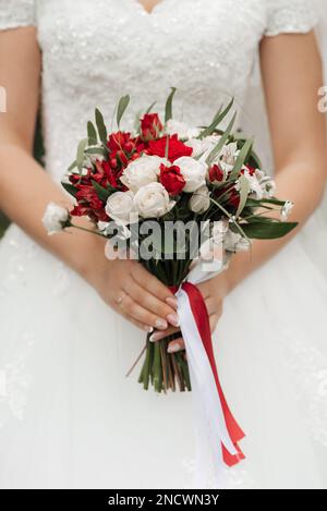 Braut mit wunderschönen roten Rosen in den Händen, Nahaufnahme Stockfoto