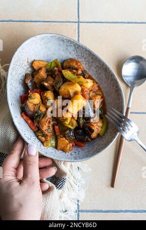 Blick von oben auf eine Frau mit einer Schüssel traditioneller georgischer Aubergine (Adjapsandali) Stockfoto