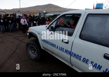 A man in a vehicle makes his way past the press at the entrance to the San Jose Mine near Copiapo, Chile Saturday, Oct. 9, 2010. Sixty-six agonizing days after their gold and copper mine collapsed above them, 33 miners were offered a way out Saturday as a drill broke through to their underground purgatory. Word of the drill's success prompted cheers, tears and the ringing of bells by families in the tent camp outside the mine. Some who have kept a vigil since the Aug. 5 disaster ran up a hill where 33 Chilean flags were planted, chanting and shouting with joy as a siren rang throughout 'Camp H