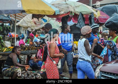 Einkaufen und Verkaufen auf dem geschäftigen Monrovia - Gbarnga Highway. Der Markt ist sehr geschäftig, und die Anbieter nehmen einen Teil der Straße ein, was zu starken Staus führt. Liberia. Stockfoto