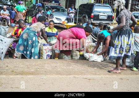 Einkaufen und Verkaufen auf dem geschäftigen Monrovia - Gbarnga Highway. Der Markt ist sehr geschäftig, und die Anbieter nehmen einen Teil der Straße ein, was zu starken Staus führt. Liberia. Stockfoto