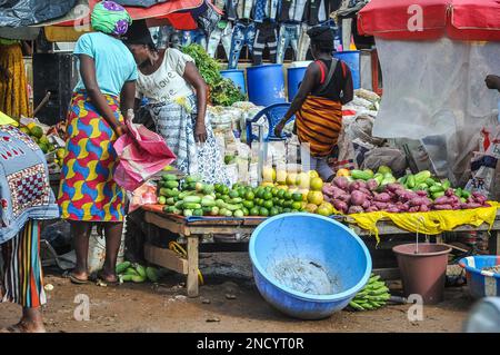 Einkaufen und Verkaufen auf dem geschäftigen Monrovia - Gbarnga Highway. Der Markt ist sehr geschäftig, und die Anbieter nehmen einen Teil der Straße ein, was zu starken Staus führt. Liberia. Stockfoto