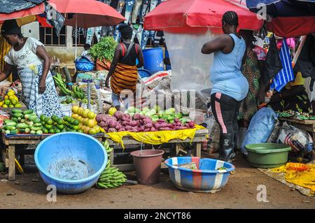 Einkaufen und Verkaufen auf dem geschäftigen Monrovia - Gbarnga Highway. Der Markt ist sehr geschäftig, und die Anbieter nehmen einen Teil der Straße ein, was zu starken Staus führt. Liberia. Stockfoto