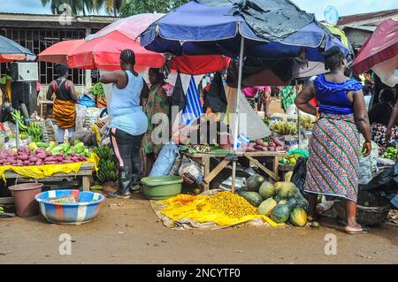 Einkaufen und Verkaufen auf dem geschäftigen Monrovia - Gbarnga Highway. Der Markt ist sehr geschäftig, und die Anbieter nehmen einen Teil der Straße ein, was zu starken Staus führt. Liberia. Stockfoto