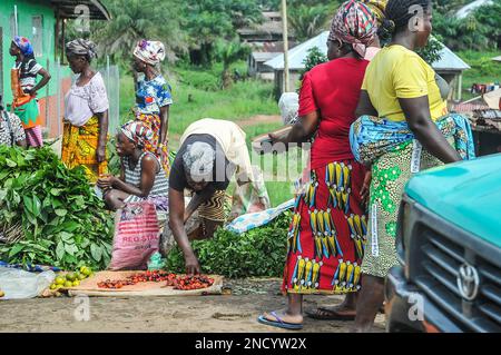 Einkaufen und Verkaufen auf dem geschäftigen Monrovia - Gbarnga Highway. Der Markt ist sehr geschäftig, und die Anbieter nehmen einen Teil der Straße ein, was zu starken Staus führt. Liberia. Stockfoto