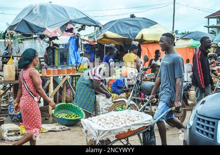 Einkaufen und Verkaufen auf dem geschäftigen Monrovia - Gbarnga Highway. Der Markt ist sehr geschäftig, und die Anbieter nehmen einen Teil der Straße ein, was zu starken Staus führt. Liberia. Stockfoto