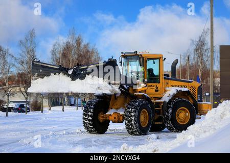 Schneeräumen mit dem Radlader Volvo L70E mit Schneepflug nach Schneefall an einem Wintertag. Salo, Finnland. 11. Februar 2023. Stockfoto