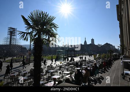 Stuttgart, Deutschland. 15. Februar 2023. Bei hellem Sonnenschein sitzen Passanten in einem offenen Café am Schlossplatz in Stuttgart. Kredit: Bernd Weißbrod/dpa/Alamy Live News Stockfoto