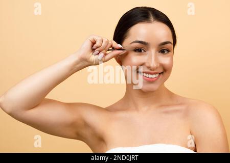 Porträt Einer Wunderschönen Jungen Indianerin, Die Mit Einer Pinzette Augenbrauen Pflückt Stockfoto