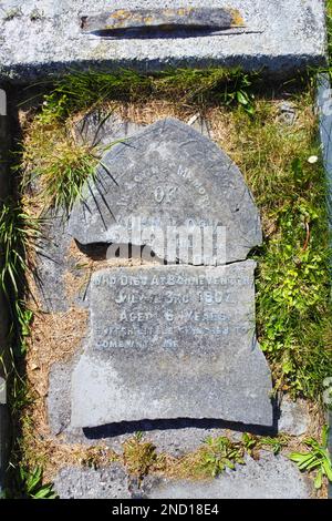 Gebrochener Grabstein markiert den Tod eines sechsjährigen Kindes, Grade Church, Cadgwith, Cornwall, Großbritannien - John Gollop Stockfoto