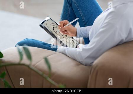 Ein zugeschnittenes Foto einer jungen Frau zeichnet ein wunderschönes Bild auf dem digitalen Pad-Bildschirm. Grafikdesigner, der zu Hause arbeitet. Stockfoto