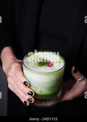 Unbekannte Frau mit Gläsern grüner Matcha-Cocktails mit Milch Stockfoto