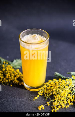 Nahaufnahme des Mimosa-Cocktails im Glas auf einem Tisch aus schwarzem Stein Stockfoto